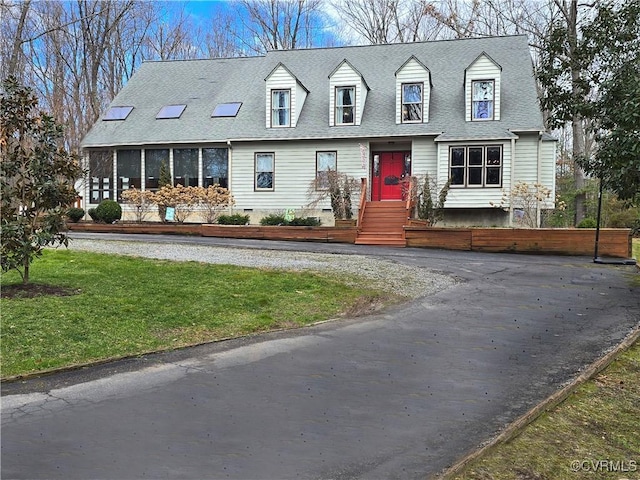 new england style home with crawl space, a front lawn, and roof with shingles