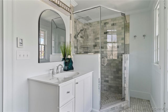 full bathroom with tile patterned floors, ornamental molding, a shower stall, baseboards, and vanity