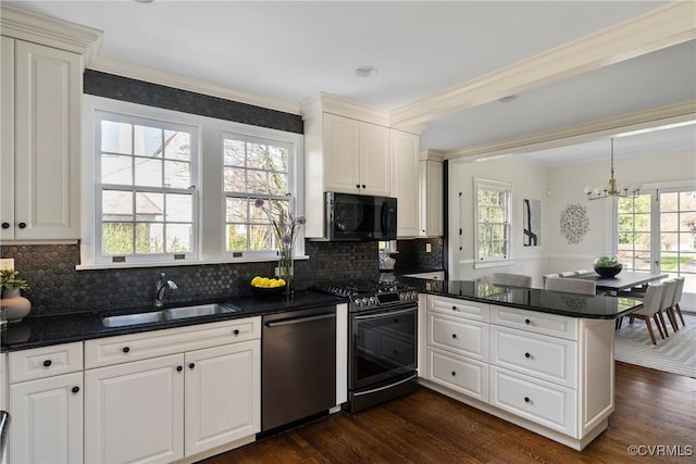 kitchen featuring a sink, black microwave, gas range, a peninsula, and stainless steel dishwasher