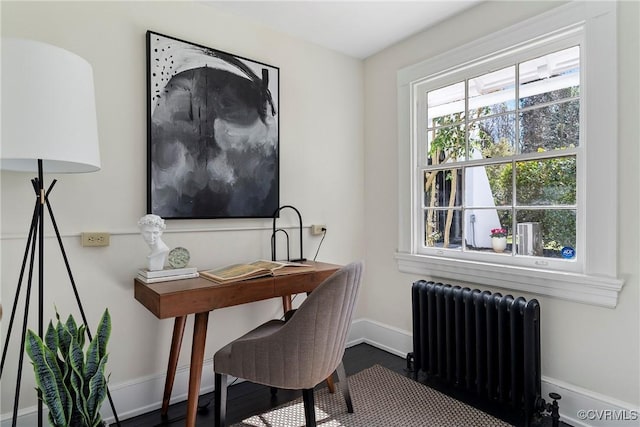 office space featuring baseboards and radiator