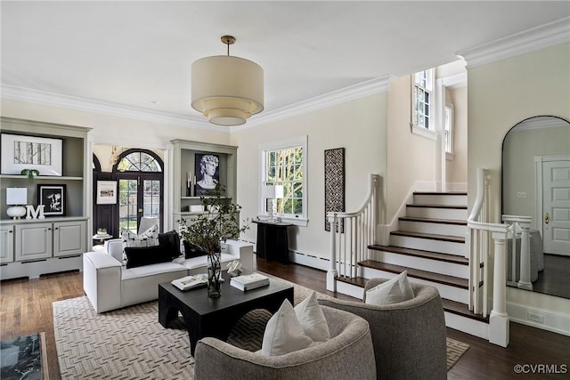 living area with a wealth of natural light, wood finished floors, stairs, and ornamental molding