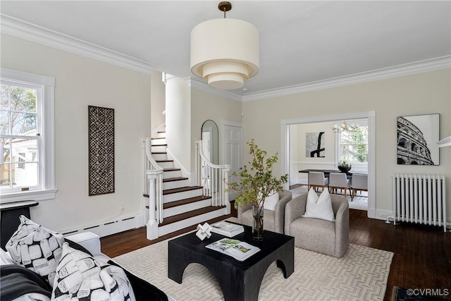 living room with crown molding, radiator heating unit, wood finished floors, and baseboard heating