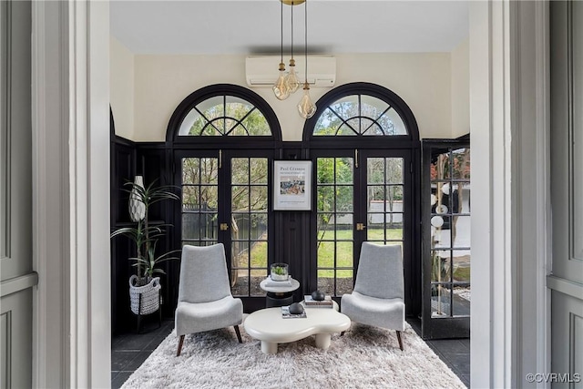 sitting room featuring tile patterned flooring, french doors, and a wall mounted air conditioner