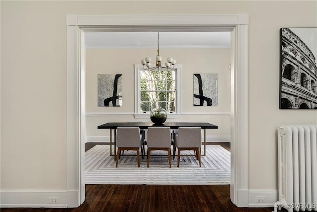 dining room featuring radiator, baseboards, ornamental molding, an inviting chandelier, and dark wood-style flooring