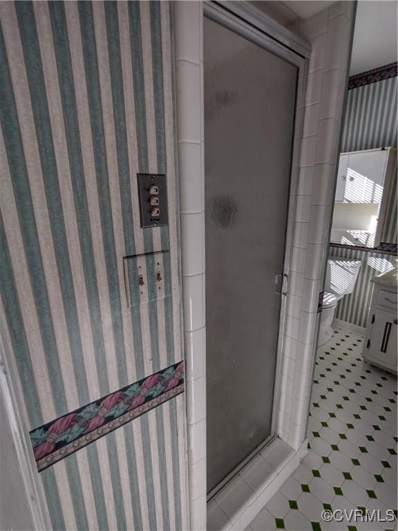 bathroom with a stall shower, tile patterned flooring, and wallpapered walls