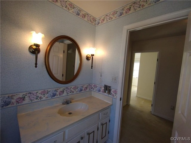 bathroom featuring wallpapered walls and vanity