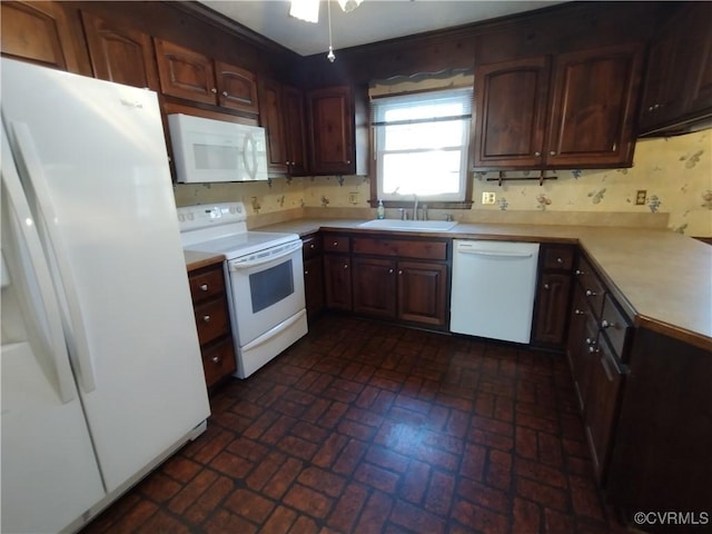 kitchen with brick floor, light countertops, a sink, ceiling fan, and white appliances