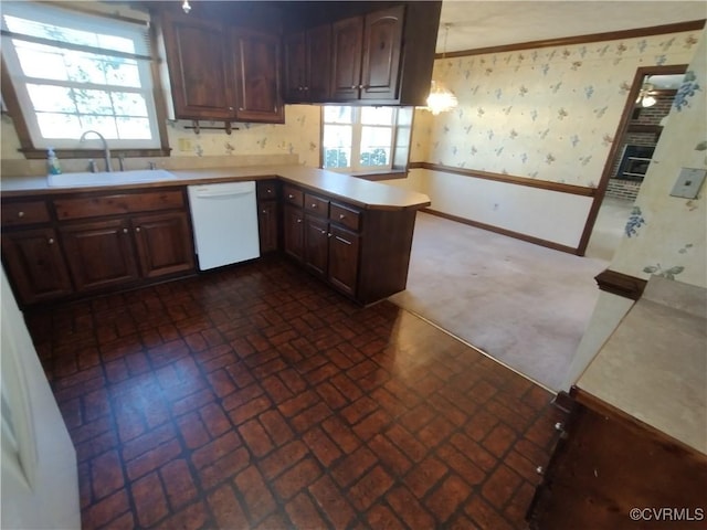 kitchen featuring wallpapered walls, white dishwasher, light countertops, crown molding, and a sink