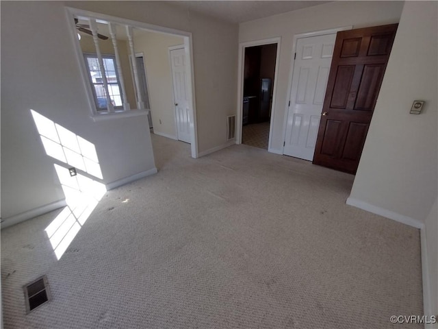 carpeted empty room featuring visible vents and baseboards