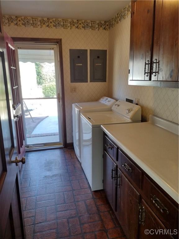 laundry room with washing machine and dryer, electric panel, cabinet space, and wallpapered walls