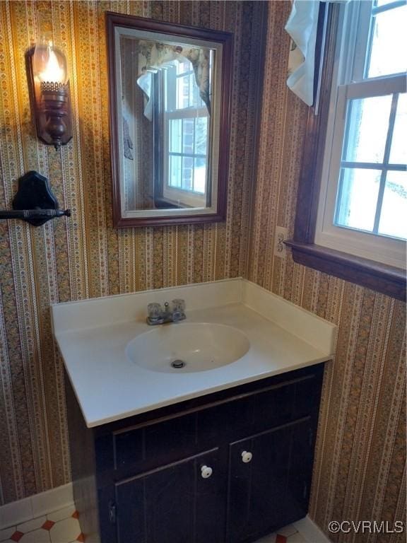 bathroom with wallpapered walls and vanity