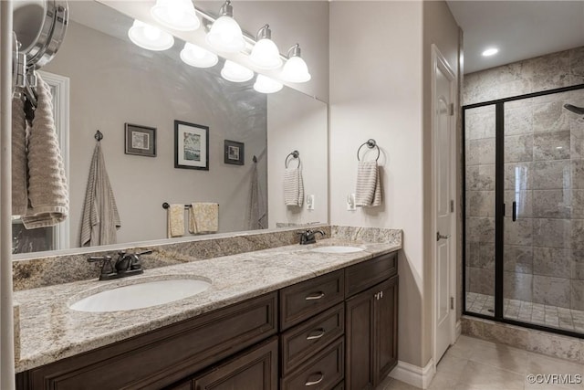 full bathroom with tile patterned floors, double vanity, a stall shower, and a sink