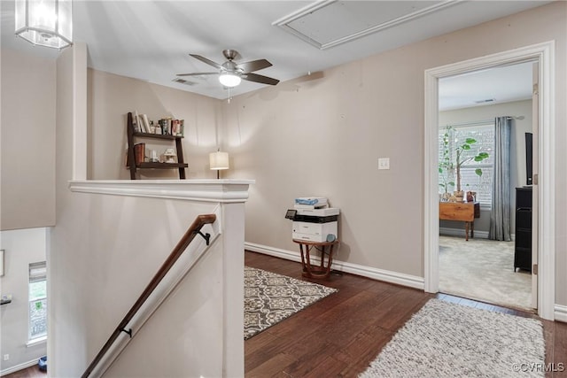 hall featuring visible vents, an upstairs landing, wood finished floors, baseboards, and attic access