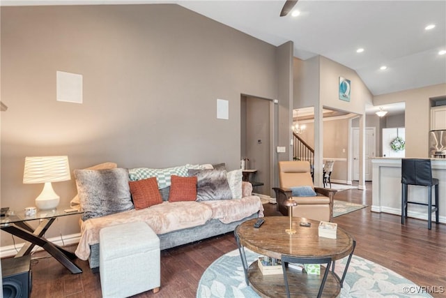 living room featuring wood finished floors, stairs, baseboards, and vaulted ceiling