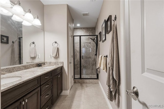 full bath with tile patterned flooring, double vanity, a stall shower, and a sink