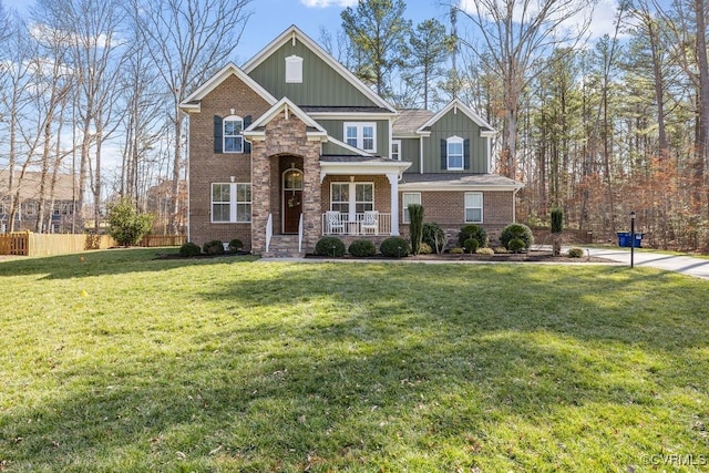 craftsman-style house featuring fence, a front lawn, a porch, board and batten siding, and brick siding