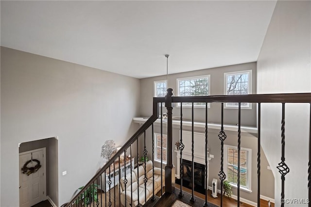 stairway featuring a fireplace and baseboards