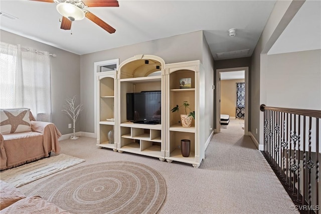 living area featuring carpet floors, visible vents, ceiling fan, and baseboards