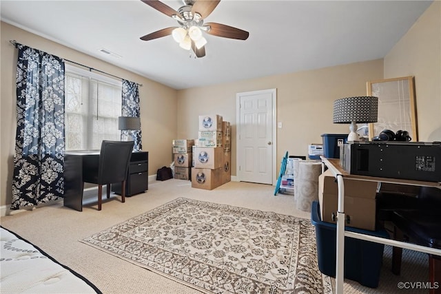 carpeted home office featuring baseboards, visible vents, and a ceiling fan