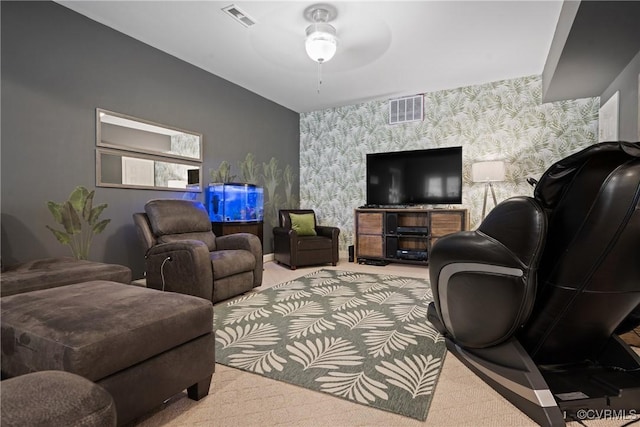 carpeted living room featuring an accent wall, a ceiling fan, visible vents, and wallpapered walls