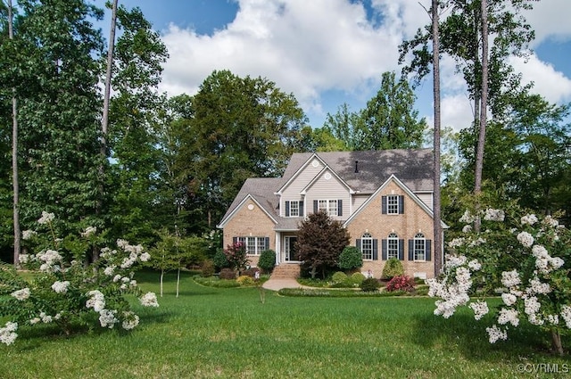 view of front of property featuring a front lawn and brick siding