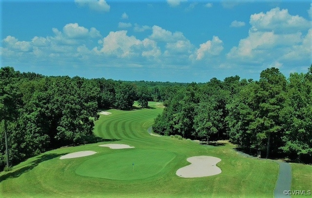 view of property's community with golf course view and a wooded view