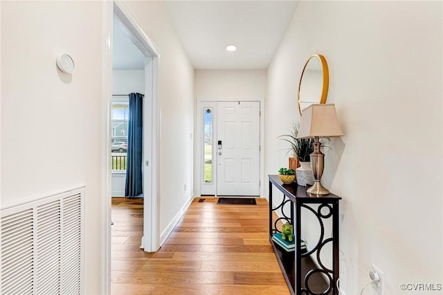 entryway with visible vents, light wood-type flooring, and baseboards