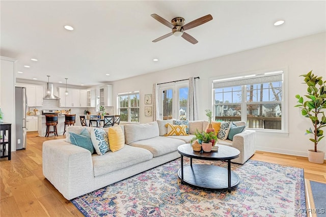 living area featuring light wood-style flooring, recessed lighting, a ceiling fan, and baseboards