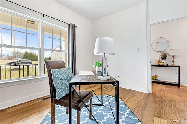 office area featuring visible vents, baseboards, and wood finished floors