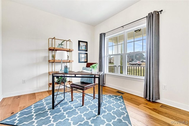 office area featuring visible vents, baseboards, and wood-type flooring