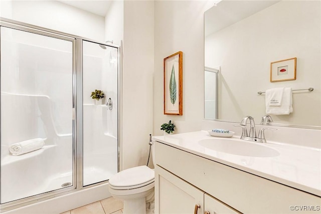 bathroom with tile patterned flooring, a shower stall, toilet, and vanity