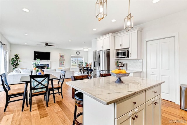 kitchen with light wood-type flooring, appliances with stainless steel finishes, and a healthy amount of sunlight