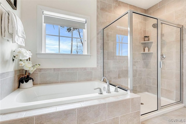 bathroom featuring a shower stall, a bath, and tile patterned floors