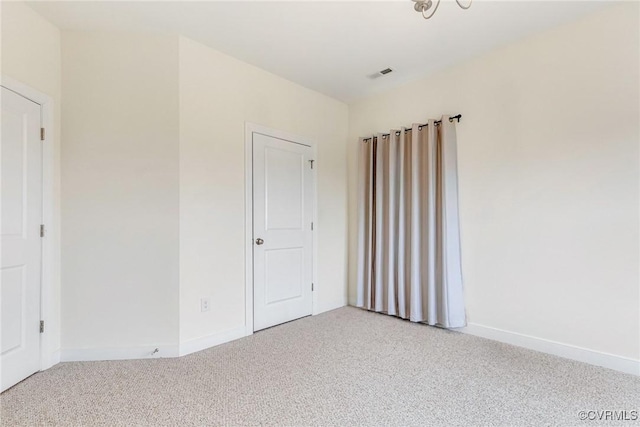 unfurnished bedroom with carpet, visible vents, and baseboards