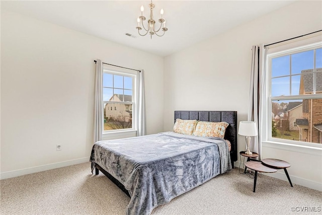 carpeted bedroom featuring an inviting chandelier, baseboards, and visible vents