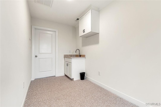 clothes washing area with light carpet, visible vents, and baseboards