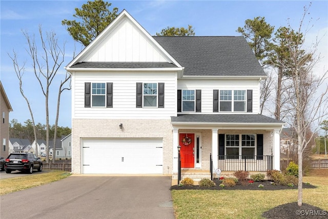 view of front facade featuring a front yard, brick siding, a porch, and driveway