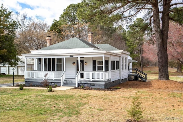 view of front facade with crawl space, a chimney, a porch, and a front yard