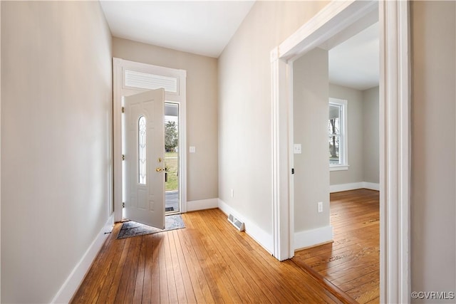 foyer entrance with light wood-style flooring, visible vents, and baseboards