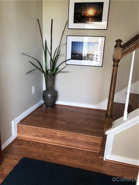 staircase with wood finished floors and baseboards