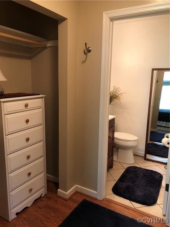 bathroom with tile patterned flooring, baseboards, vanity, and toilet