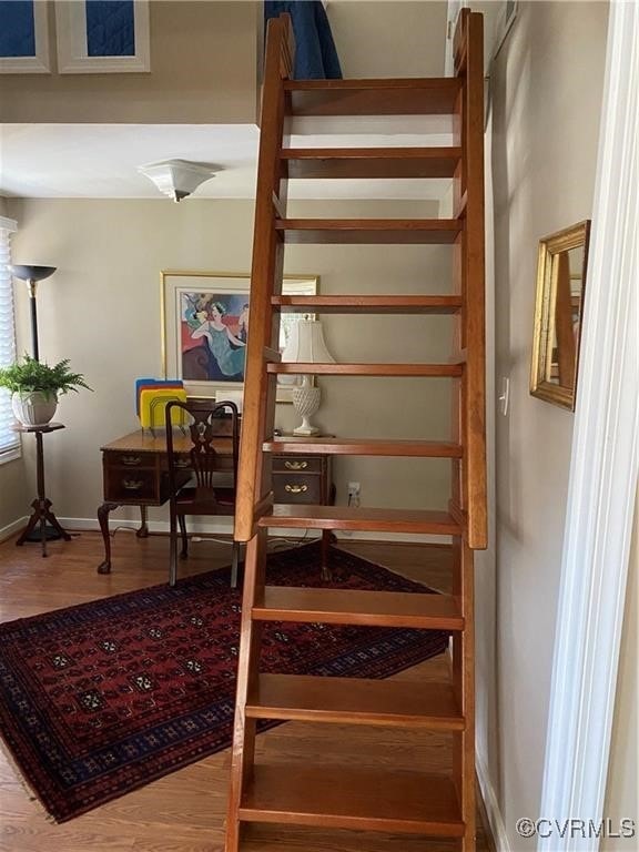 staircase with wood finished floors and baseboards