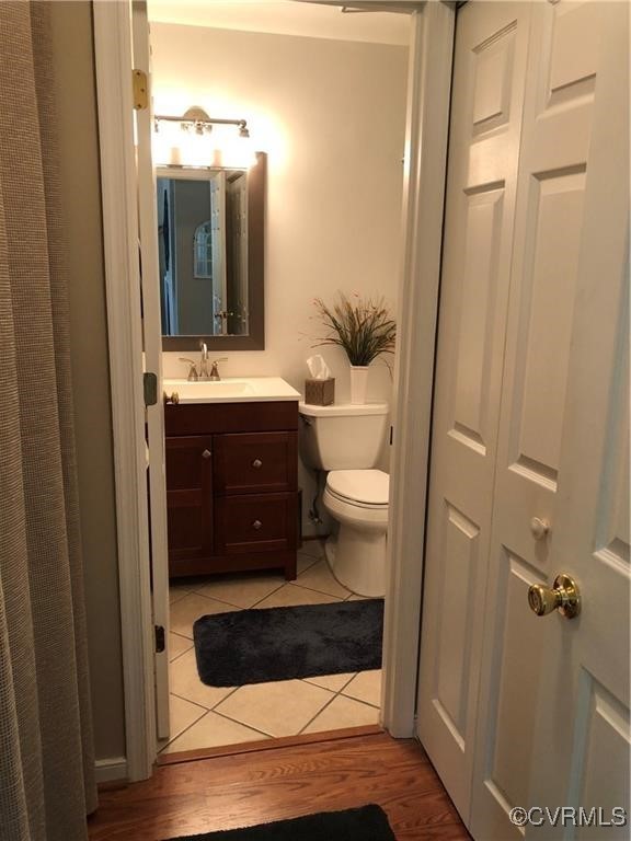 full bathroom featuring toilet, wood finished floors, and vanity