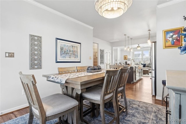 dining area with ornamental molding, dark wood finished floors, and baseboards