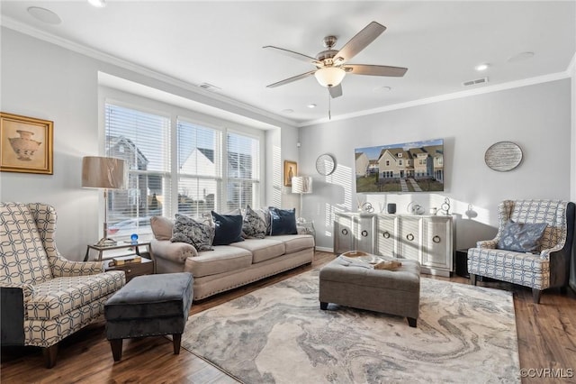 living room featuring visible vents, crown molding, and wood finished floors