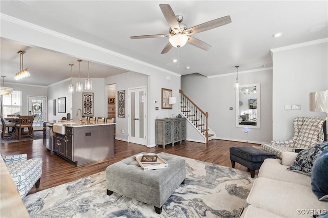 living area with baseboards, stairway, dark wood-style flooring, and ornamental molding