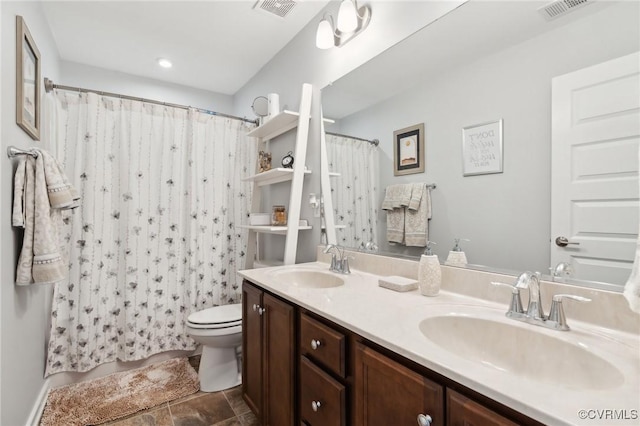 bathroom featuring toilet, a sink, and visible vents