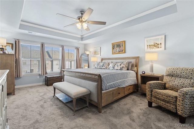 bedroom featuring light carpet, baseboards, visible vents, and a tray ceiling