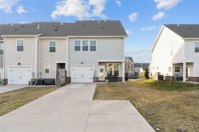 rear view of house featuring a yard, driveway, an attached garage, and central AC unit