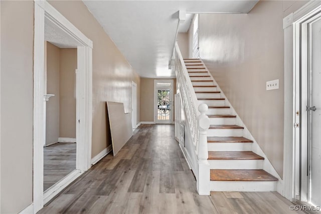 stairs with baseboards and wood finished floors